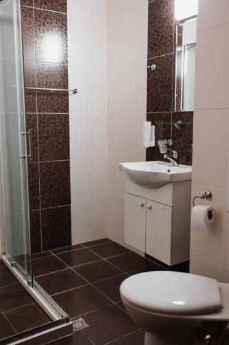 a bathroom with a shower and a toilet and a sink at Hotel Neptun in Vidin