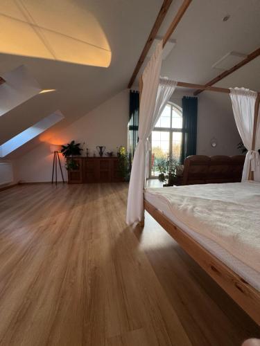 a bedroom with a large bed and a wooden floor at Apartament Jezioro Łabędzie in Białla