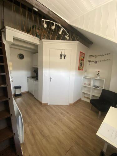 - un salon avec des murs blancs et un escalier dans l'établissement Studio centre ville Besançon - vue Citadelle, à Besançon