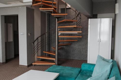 a spiral staircase in a living room with a couch at Hotel Neptun in Vidin