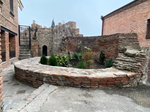 a stone retaining wall with a garden in front of a building at Boutique Hotel Tiflis in Tbilisi City