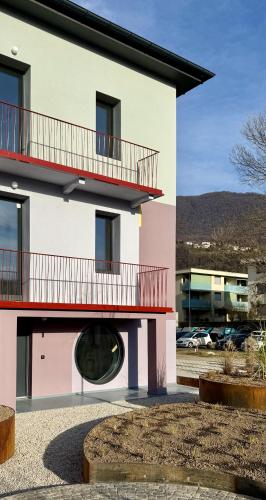a pink and white building with a round window at Casa Oblò in Mendrisio