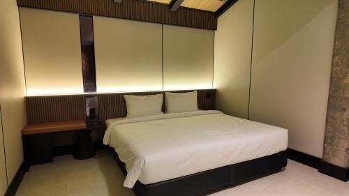 a small bedroom with a bed and a chair at Urban Inn Cyberjaya in Cyberjaya