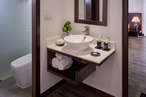 a bathroom with a sink and a toilet at Hoi An Odyssey Hotel & Spa in Hoi An