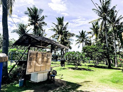 a sign in a park with palm trees at ZHANG RESORT and DIVE CENTER in Daanbantayan