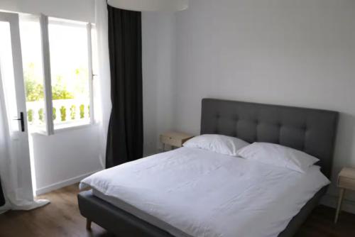 a bedroom with a white bed with a window at Apartman Rabtours in Kampor