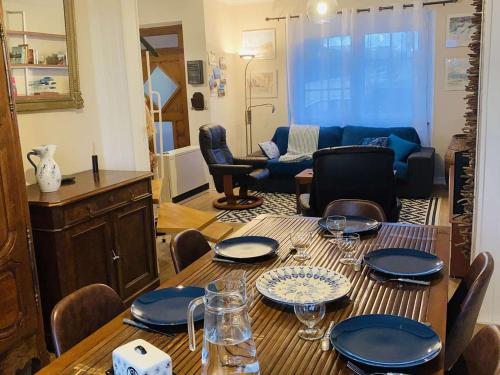 une table de salle à manger avec des assiettes et des verres dessus dans l'établissement Maison 3*** à 300m de la plage, jardin privé, Wifi inclus, proche commerces, 6 pers., non-fumeurs - FR-1-542-47, à Pleumeur-Bodou