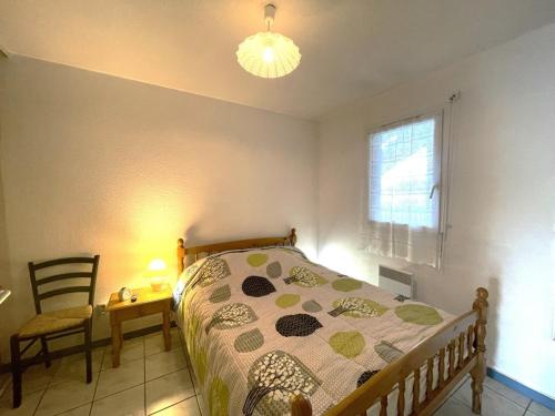 une chambre avec un lit, une chaise et une fenêtre dans l'établissement T2 cabine 6 pers, terrasse, parking, animaux acceptés - FR-1-379-141, à Vieux-Boucau-les-Bains