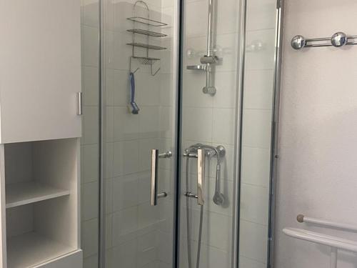 une douche avec une porte vitrée dans une salle de bain dans l'établissement T2 cabine 6 pers, terrasse, parking, animaux acceptés - FR-1-379-141, à Vieux-Boucau-les-Bains