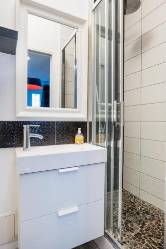 une salle de bain avec un lavabo blanc et une douche dans l'établissement Studio au centre de Paris, à Paris