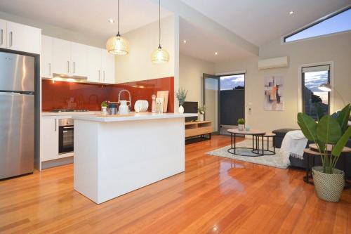 cocina y sala de estar con encimera blanca en Luxury Townhouse Stay, en Melbourne