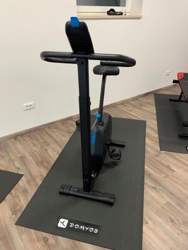 a black exercise bike on a black mat on the floor at Hotel Weingarten in Caldaro