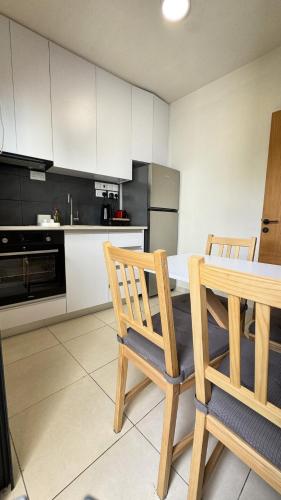 a kitchen with a table and two wooden chairs at City Centre 2-Bedroom, Old Town, Nicosia in Nicosia