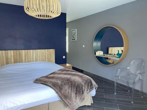 - une chambre avec un lit et un miroir rond dans l'établissement Villa Californie avec piscine près du circuit des 24H, à Changé