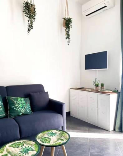 un salon avec un canapé bleu et une télévision dans l'établissement Studio Charmant, Hyper Centre, À 3min Plage NICE CENTRE, à Nice