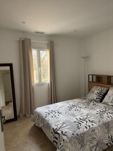 une chambre avec un lit, un miroir et une fenêtre dans l'établissement 3 chambres à côté de sarlat, dans le Périgord !, à Carsac-Aillac