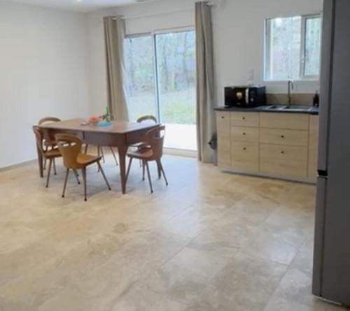 eine Küche mit Tisch und Stühlen in einem Zimmer in der Unterkunft 3 chambres à côté de sarlat, dans le Périgord ! in Carsac-Aillac