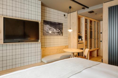 a bedroom with a bed and a tv and a table at Sport Hotel Village in Soldeu