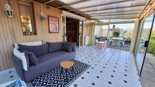 un salon avec un canapé et une table dans l'établissement Charmante Maison proche plage, à Fréhel