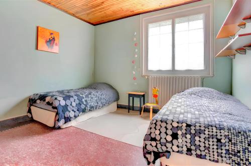 une chambre avec deux lits et une fenêtre dans l'établissement Charmante Maison proche plage, à Fréhel