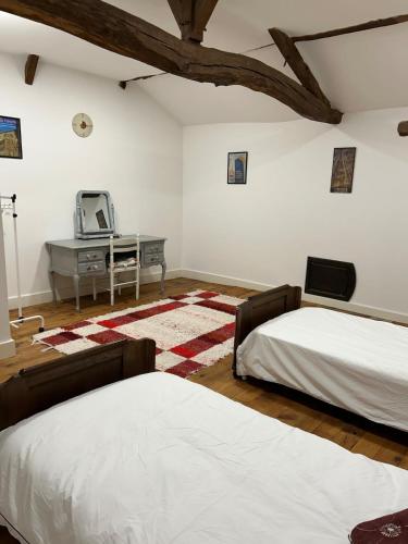 a bedroom with two beds and a desk with a tv at Beautiful Big Home with Swimming Pool and Nature Grounds in Auterrive