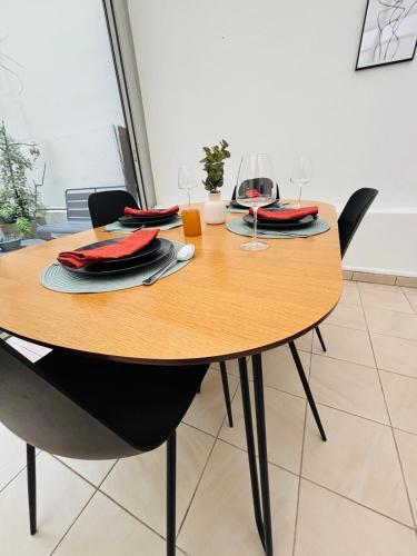- une table en bois avec des chaises et des verres à vin dans l'établissement Appartement Foch Champs Élysée, à Paris