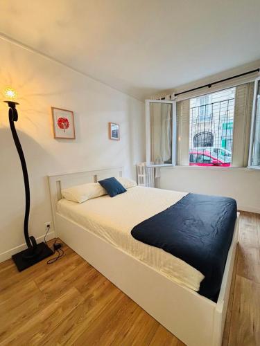 Ce lit se trouve dans une chambre dotée d'une lampe et d'une fenêtre. dans l'établissement Appartement Foch Champs Élysée, à Paris