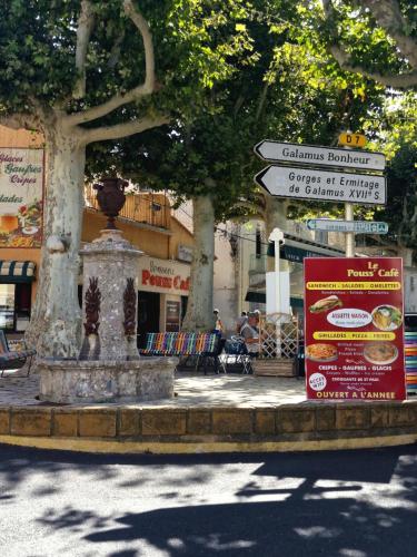un panneau de rue devant un bâtiment arboré dans l'établissement Galamus Bonheur - Tous fournis aux randonneurs, à Saint-Paul-de-Fenouillet