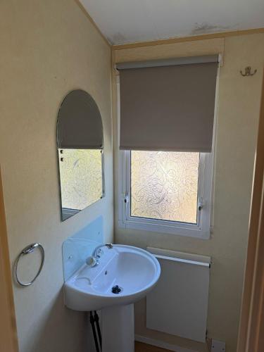a bathroom with a sink and a window at MIĘDZY NAMI domki nad jeziorem in Kołczewo