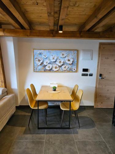 a dining room table with chairs and a painting on the wall at Luxury Villa Mašić -Apartment Ali in Bugojno