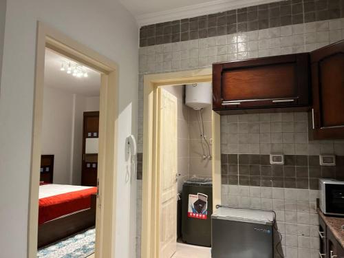 une chambre avec une cuisine et une chambre avec un lit dans l'établissement Modern Studio 1BR, Celia TMG, New Administrative, New Capital, Fully Equipped, King Bed, Ground Floor, à Kafr ash Sharā‘inah