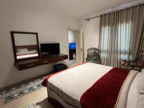 une chambre d'hôtel avec un lit et un miroir dans l'établissement Modern Studio 1BR, Celia TMG, New Administrative, New Capital, Fully Equipped, King Bed, Ground Floor, à Kafr ash Sharā‘inah