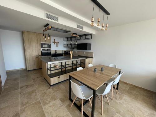 une cuisine et une salle à manger avec une table et des chaises en bois dans l'établissement Maison belle vue, à Cavalaire-sur-Mer
