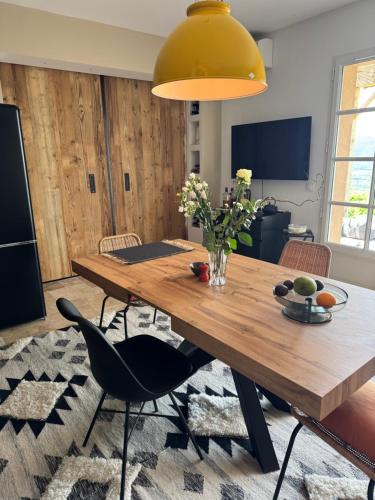 d'une salle à manger avec une table en bois et une lumière jaune. dans l'établissement La Perle de Gassin Villa with sea view Gassin St Tropez, à Gassin