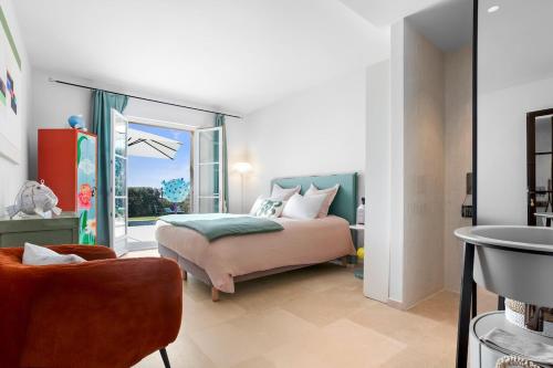 une chambre avec un lit, une fenêtre et une chaise dans l'établissement Luxury Villa, 4 bedrooms, private pool, KSS IMMO, à Port Grimaud