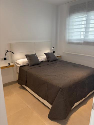 a bedroom with a bed with two pillows and a window at ICEBERG LUXURY DUNEs Free Private Parking in Tarifa