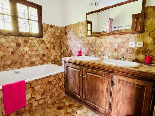 une salle de bain avec deux lavabos, une baignoire et un miroir dans l'établissement Villa au charme incroyable et piscine, à Saint-Jeannet
