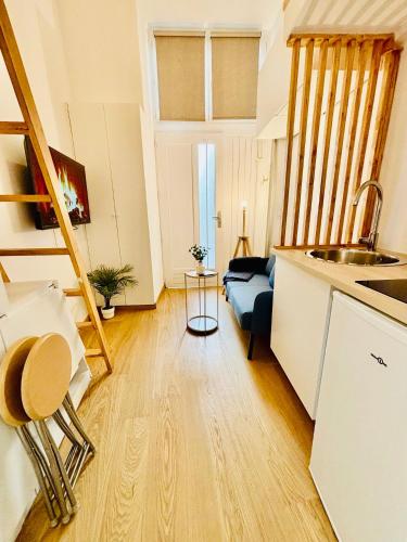 une cuisine et un salon avec un canapé dans l'établissement Studio Penthievre Champs Elysée, à Paris