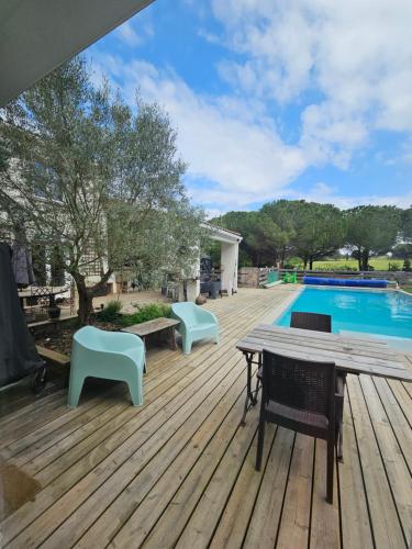 - une terrasse avec une table et des chaises à côté de la piscine dans l'établissement OXPIRA, à Palaja