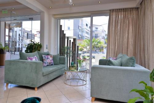 a living room with two couches and a large window at Irida Apartments in Leptokaria