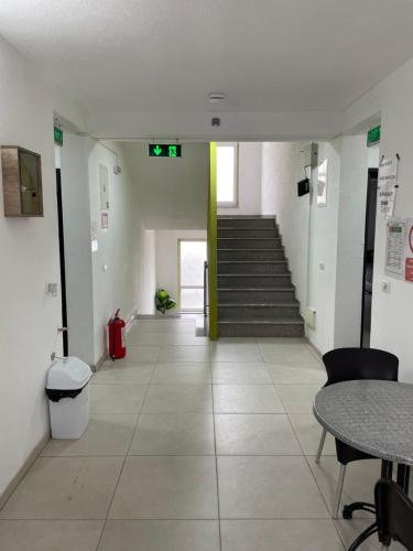 an empty hallway with stairs and a table and chairs at Bakal in Gostivar