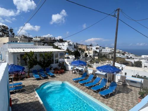 a view of a swimming pool with chairs and umbrellas at Stella Nomikou Apartments in Firostefani