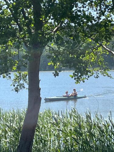 two people in a canoe on a lake at MIĘDZY NAMI domki nad jeziorem in Kołczewo