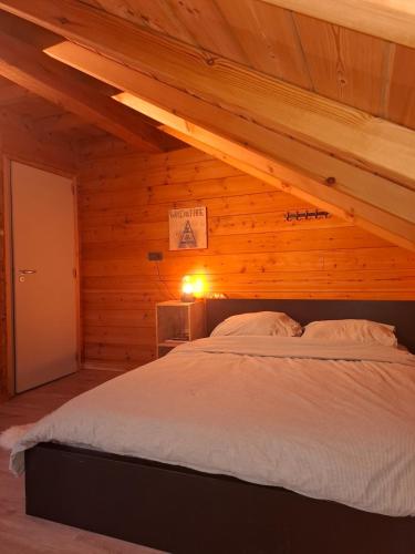 Un dormitorio con una cama en una habitación de madera. en Innersoulhouse, en Wuustwezel