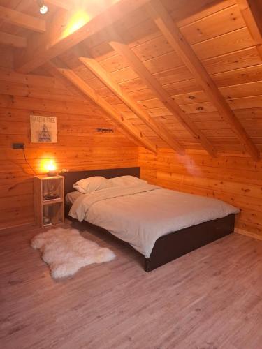 a bedroom with a bed in a wooden cabin at Innersoulhouse in Wuustwezel