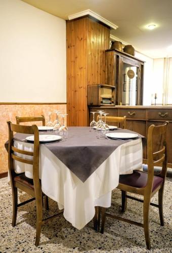 a dining room with a table with wine glasses on it at Hotel Casa Peix in Serraduy