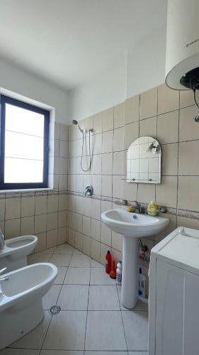 a white bathroom with a sink and a mirror at Bledi's Apartment Spille in Spille