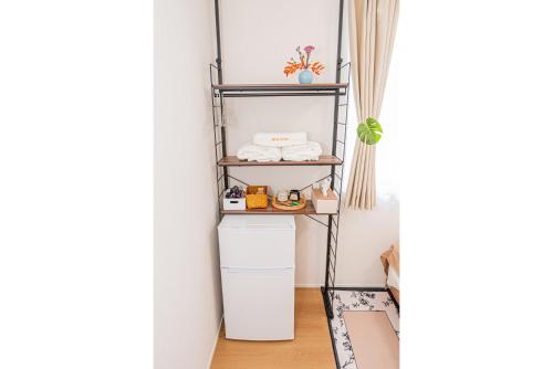 a shelf unit in a hallway with towels on it at Kamakura no Nikki in Kamakura