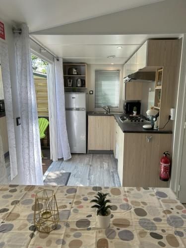 a kitchen with a refrigerator and a counter top at Mobilhome gorges de l'Ardèche proche du Pont d'Arc, camping Domaine de Chaussy 5 étoiles in Lagorce