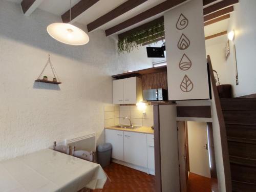 a small kitchen with a table in a room at Village Bord de Ciel in Caylus